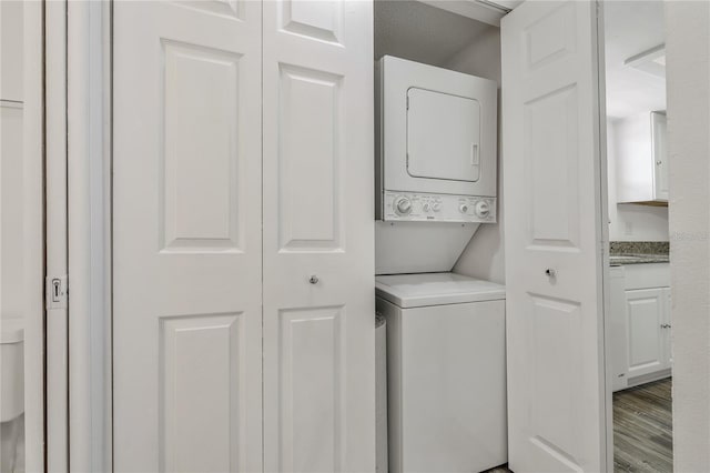 105 4th Ave NE Unit 220, Saint Petersburg, FL 33701 - clothes washing area with stacked washer / dryer, laundry area, and wood finished floors