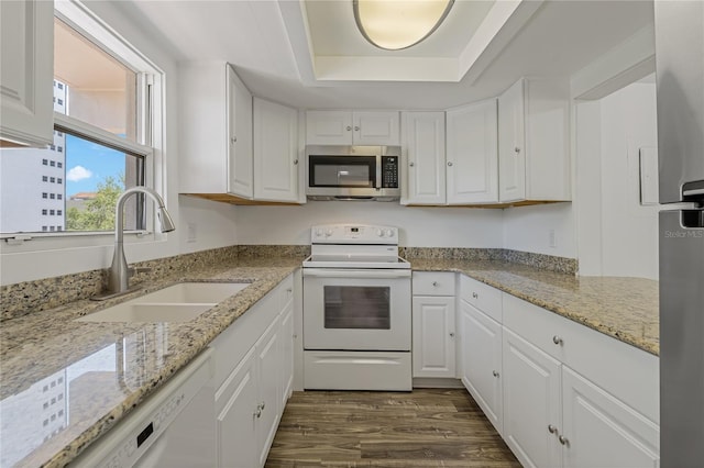 105 4th Ave NE Unit 220, Saint Petersburg, FL 33701 - kitchen with a sink, white appliances, dark wood finished floors, a tray ceiling, and white cabinetry
