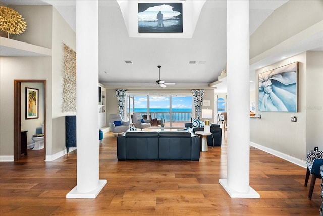 living room featuring light wood-style flooring and decorative columns