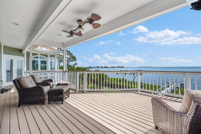 deck with a water view and ceiling fan