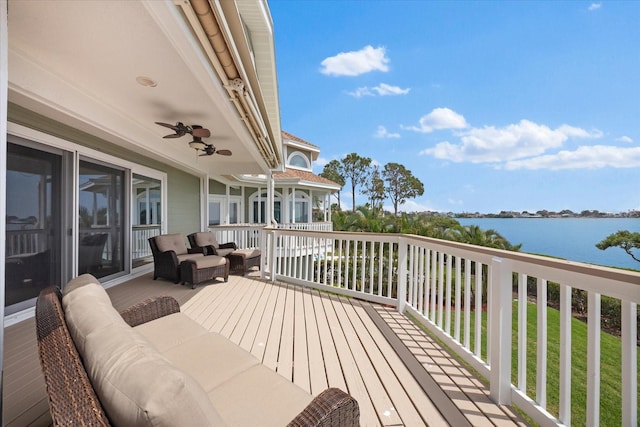 wooden deck with an outdoor hangout area, a ceiling fan, and a water view