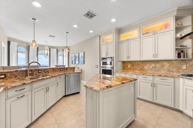 kitchen featuring stainless steel appliances, visible vents, light tile patterned floors, a sink, and decorative backsplash