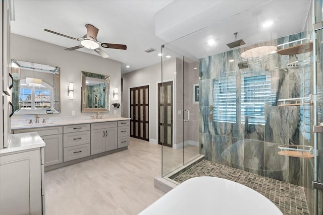 full bath featuring visible vents, a ceiling fan, a stall shower, and a sink