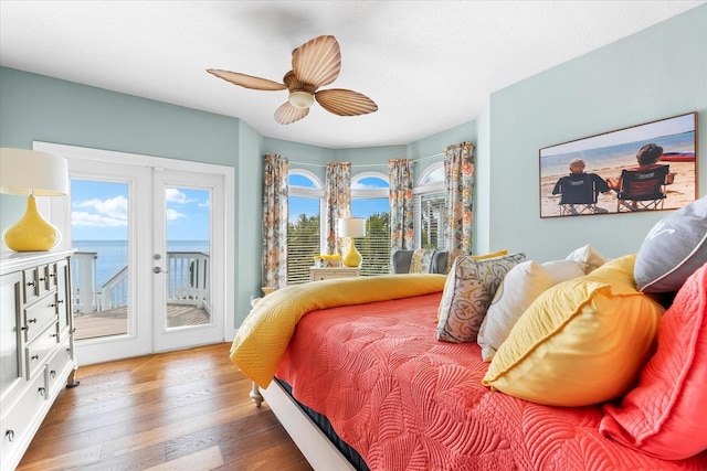 bedroom with hardwood / wood-style floors, french doors, a ceiling fan, and access to exterior