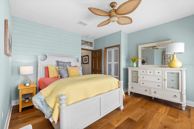 bedroom with visible vents, baseboards, wood finished floors, and a closet