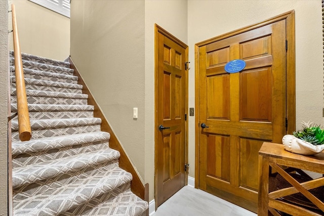 stairway featuring a textured wall