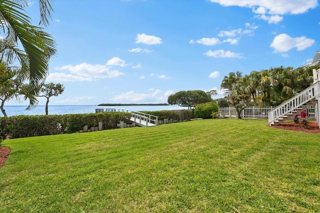 view of yard featuring fence and a water view