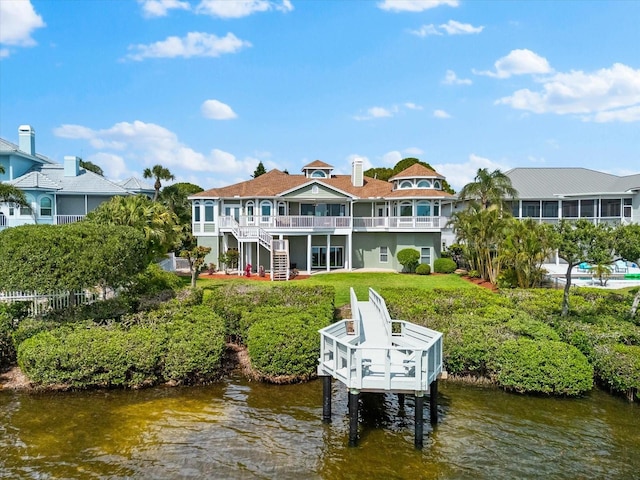 rear view of house featuring stairway and a water view