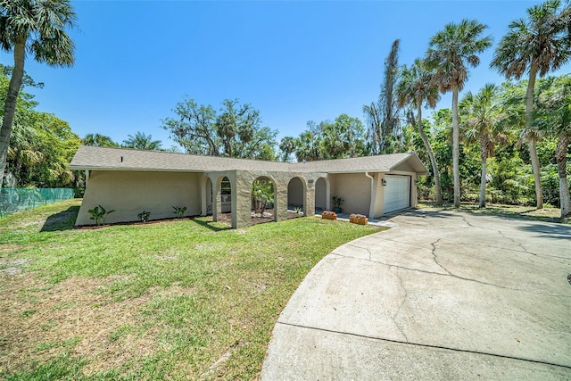 single story home with a garage, stucco siding, and a front lawn