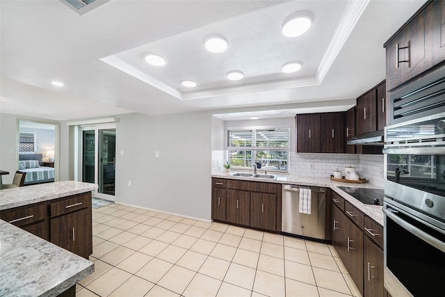 kitchen with light countertops, backsplash, stainless steel appliances, range hood, and a sink