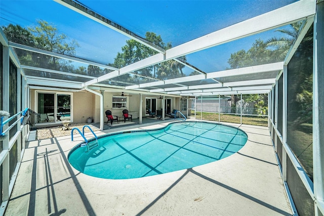 outdoor pool featuring fence, glass enclosure, and a patio