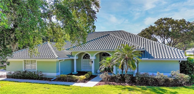 9159 Highland Ridge Way, Tampa, FL 33647 - mediterranean / spanish-style home with a tiled roof, stucco siding, and a front lawn