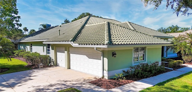 9159 Highland Ridge Way, Tampa, FL 33647 - view of front of house with a tiled roof, concrete driveway, a garage, and stucco siding