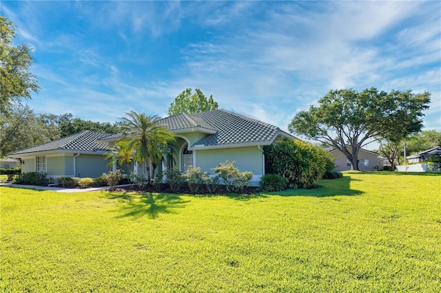 9159 Highland Ridge Way, Tampa, FL 33647 - view of property exterior featuring a yard, a tile roof, and stucco siding