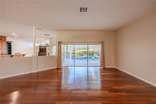 9159 Highland Ridge Way, Tampa, FL 33647 - spare room with a chandelier, baseboards, dark wood finished floors, and visible vents