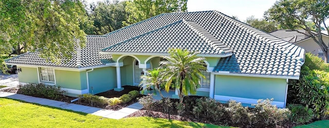 9159 Highland Ridge Way, Tampa, FL 33647 - view of front of house featuring stucco siding, a front lawn, and a tile roof