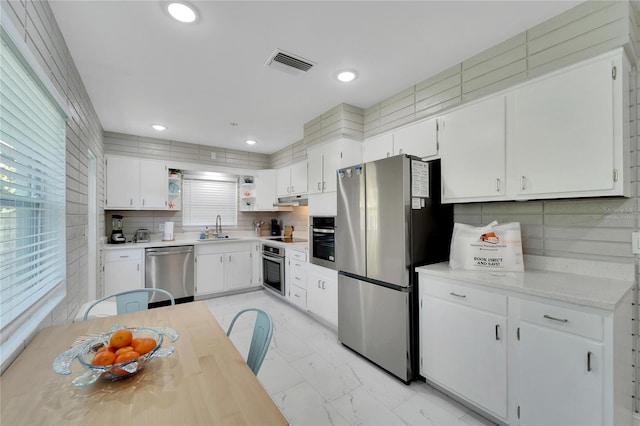 kitchen featuring white cabinets, visible vents, open shelves, under cabinet range hood, and appliances with stainless steel finishes