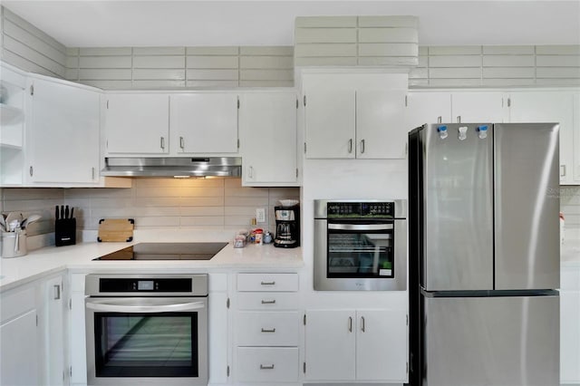 kitchen featuring white cabinets, stainless steel appliances, tasteful backsplash, light countertops, and under cabinet range hood