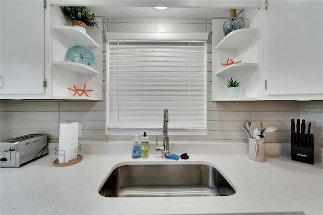 room details featuring open shelves, white cabinetry, and a sink