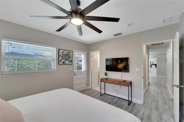 bedroom with baseboards, light wood-style floors, and visible vents