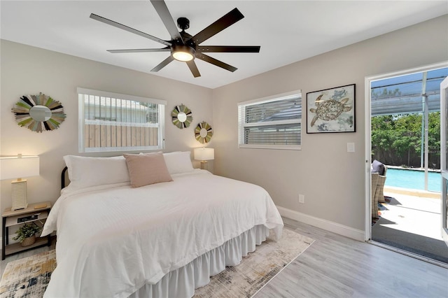 bedroom with light wood-style flooring, access to exterior, baseboards, and multiple windows