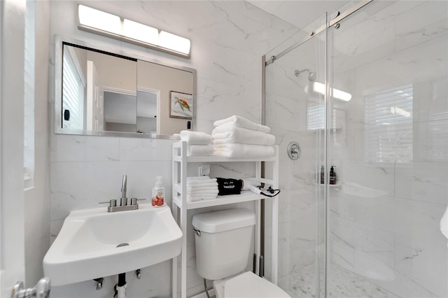 bathroom featuring toilet, a sink, and a marble finish shower