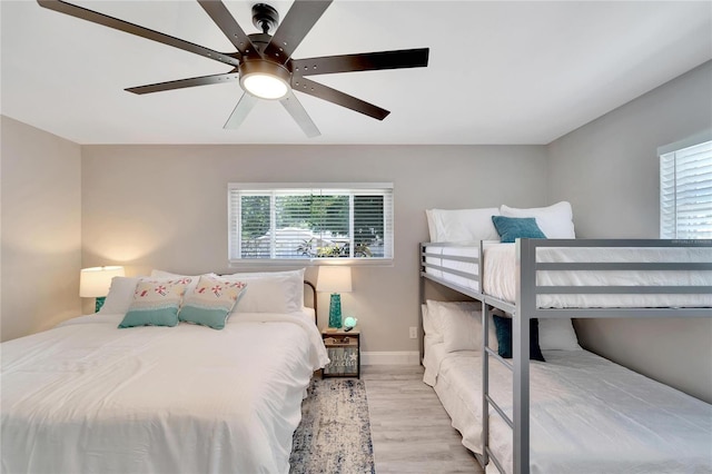bedroom with wood finished floors, a ceiling fan, and baseboards