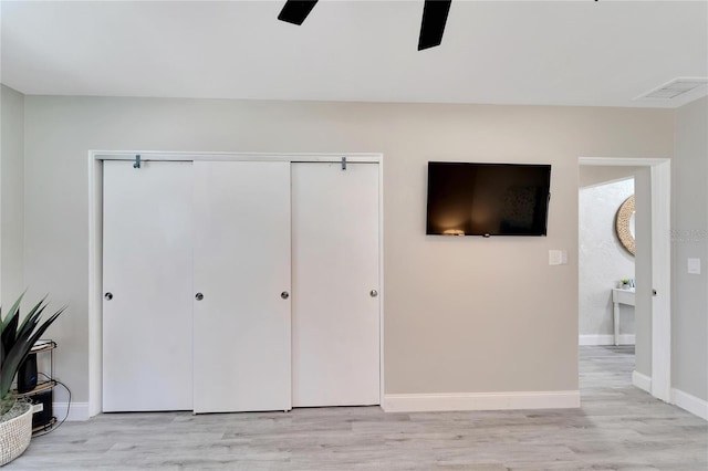 interior space with light wood-style flooring, a closet, baseboards, and visible vents