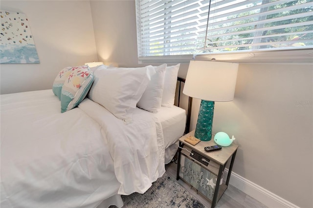bedroom featuring baseboards and wood finished floors