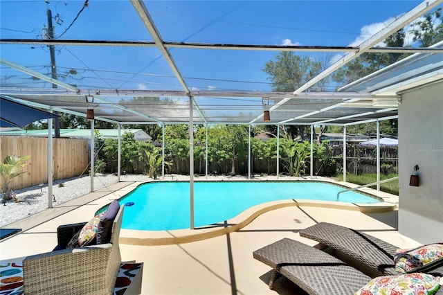 view of swimming pool with glass enclosure, a patio area, a fenced in pool, and a fenced backyard