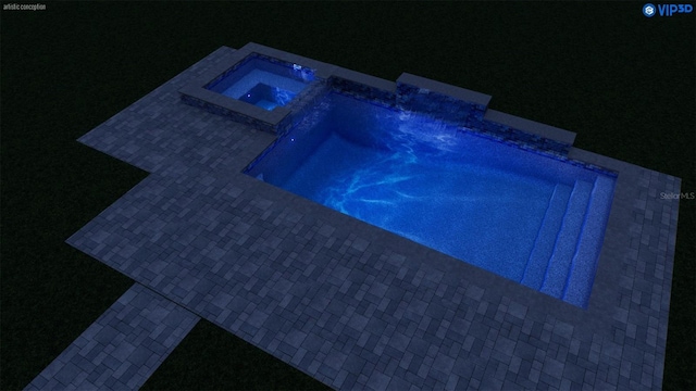 pool at night with an outdoor pool and an in ground hot tub