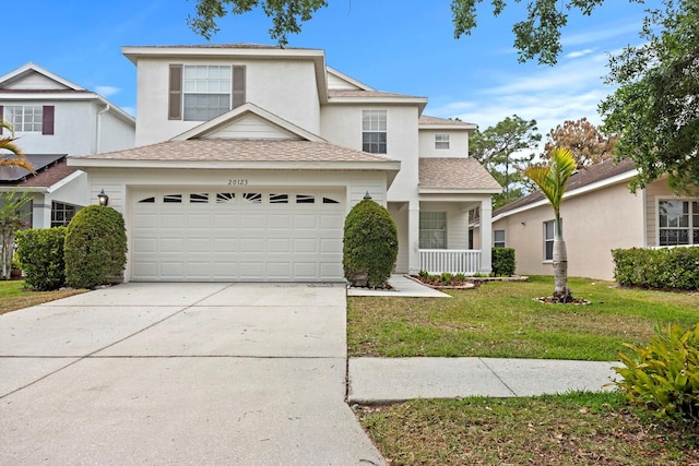 20123 Bay Cedar Ave, Tampa, FL 33647 - traditional-style house with a front lawn, driveway, an attached garage, stucco siding, and roof with shingles