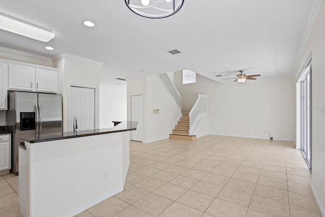 20123 Bay Cedar Ave, Tampa, FL 33647 - kitchen featuring light tile patterned flooring, crown molding, dark countertops, a ceiling fan, and stainless steel fridge with ice dispenser