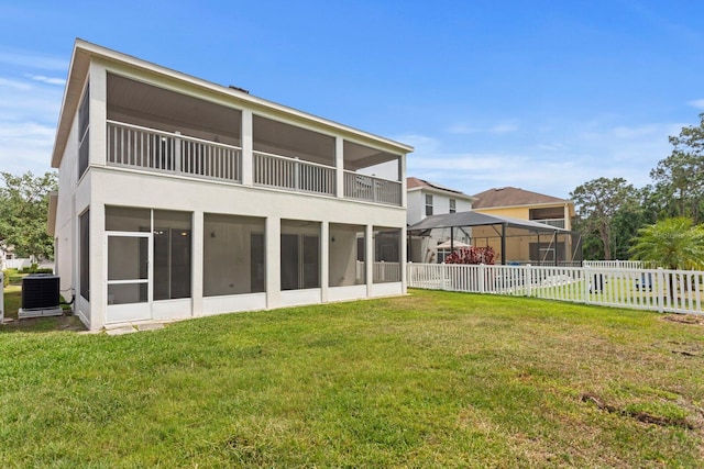 20123 Bay Cedar Ave, Tampa, FL 33647 - rear view of house featuring cooling unit, a yard, a sunroom, and fence