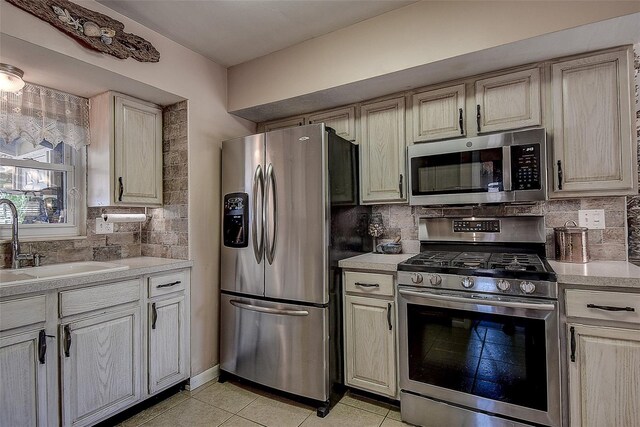 5931 33rd Ave N, Saint Petersburg, FL 33710 - kitchen with light countertops, a sink, appliances with stainless steel finishes, and tasteful backsplash