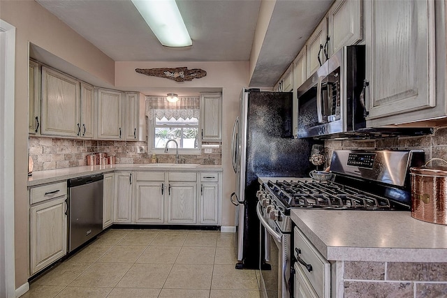 5931 33rd Ave N, Saint Petersburg, FL 33710 - kitchen featuring backsplash, appliances with stainless steel finishes, a sink, and light tile patterned floors