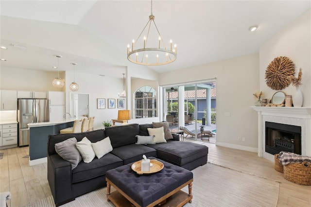 living room with light wood-style flooring, recessed lighting, a chandelier, lofted ceiling, and a fireplace