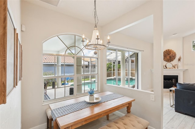 dining space with an inviting chandelier, baseboards, visible vents, and a fireplace