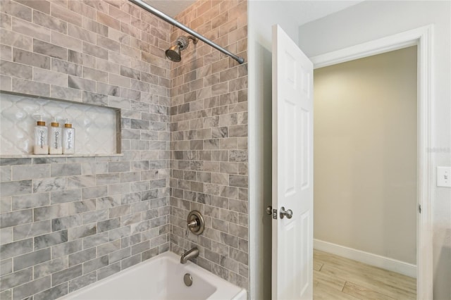 full bath with shower / bathtub combination, baseboards, and wood finished floors