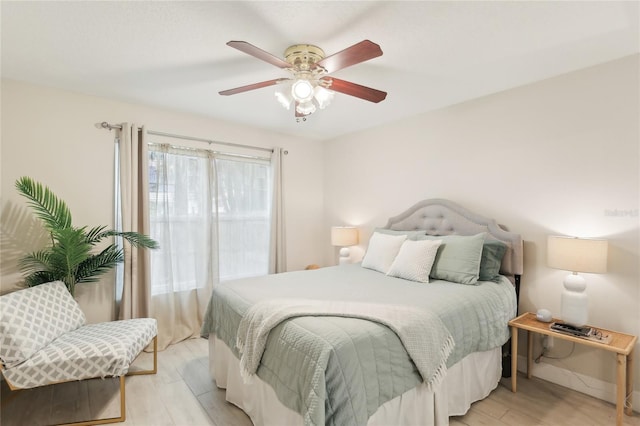 bedroom featuring ceiling fan, baseboards, and light wood-type flooring