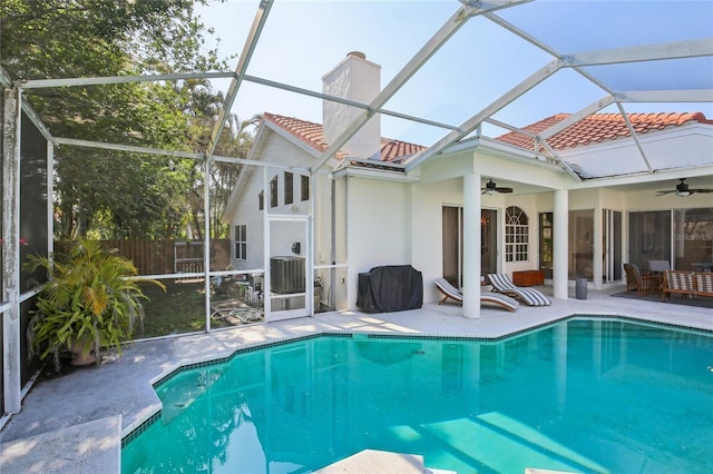 rear view of property featuring a ceiling fan, a patio area, a chimney, and a tiled roof