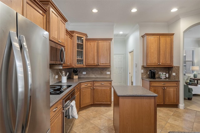 27318 Sora Blvd, Wesley Chapel, FL 33544 - kitchen featuring dark countertops, arched walkways, brown cabinets, and appliances with stainless steel finishes