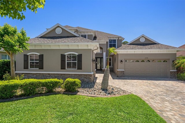 27318 Sora Blvd, Wesley Chapel, FL 33544 - view of front of property with stucco siding, roof with shingles, a front lawn, a garage, and driveway