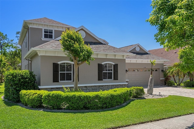 27318 Sora Blvd, Wesley Chapel, FL 33544 - view of front facade with stucco siding, stone siding, decorative driveway, an attached garage, and a front yard