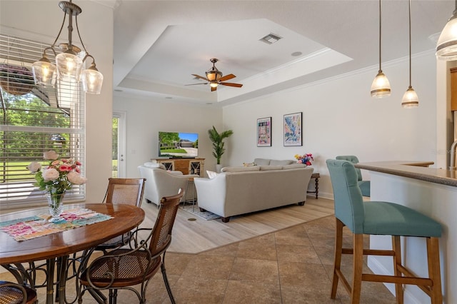 27318 Sora Blvd, Wesley Chapel, FL 33544 - living room with light tile patterned floors, visible vents, a tray ceiling, and ceiling fan