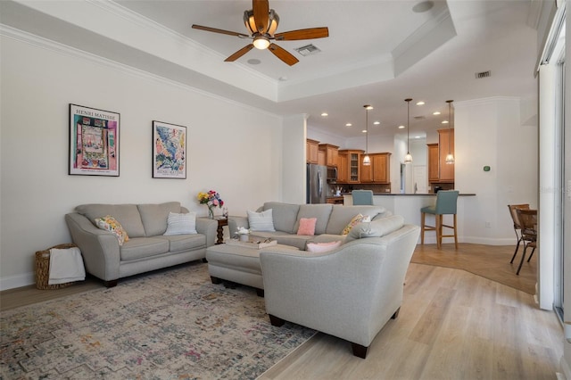 27318 Sora Blvd, Wesley Chapel, FL 33544 - living room with visible vents, a raised ceiling, a ceiling fan, recessed lighting, and light wood-style flooring