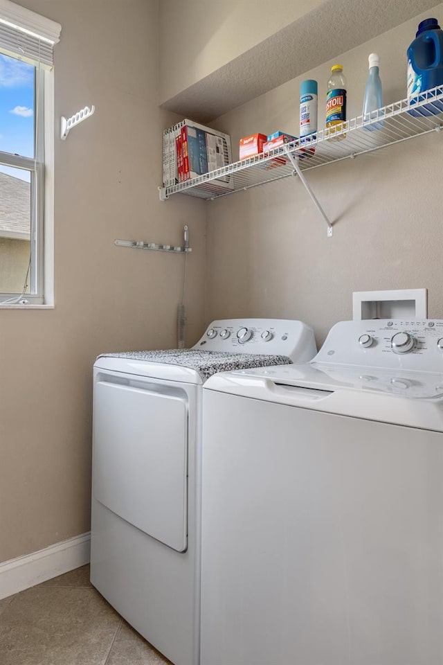 27318 Sora Blvd, Wesley Chapel, FL 33544 - clothes washing area with washer and dryer, laundry area, light tile patterned flooring, and baseboards