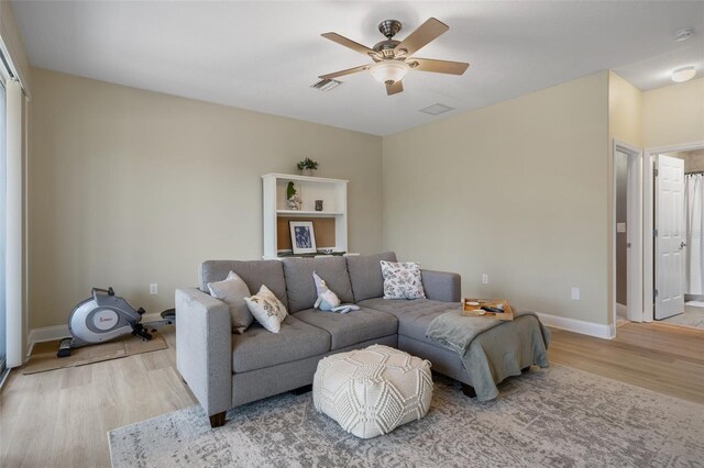 27318 Sora Blvd, Wesley Chapel, FL 33544 - living area with light wood-style flooring, ceiling fan, baseboards, and visible vents