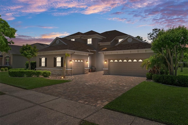 27318 Sora Blvd, Wesley Chapel, FL 33544 - view of front facade featuring stucco siding, an attached garage, decorative driveway, stone siding, and a front yard
