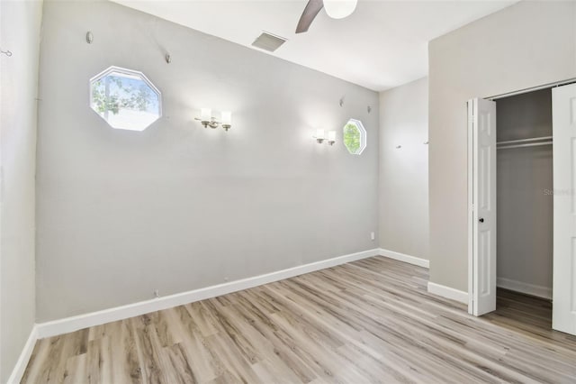 unfurnished bedroom with visible vents, wood finished floors, and multiple windows
